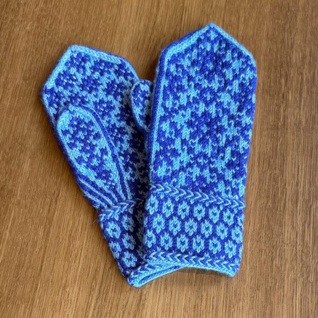 A pair of blue colorwork mittens.
